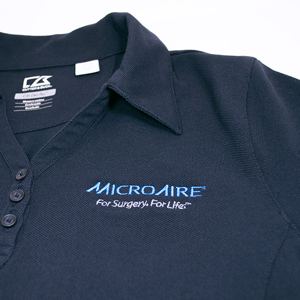 medical device company logo on dark gray collared shirt